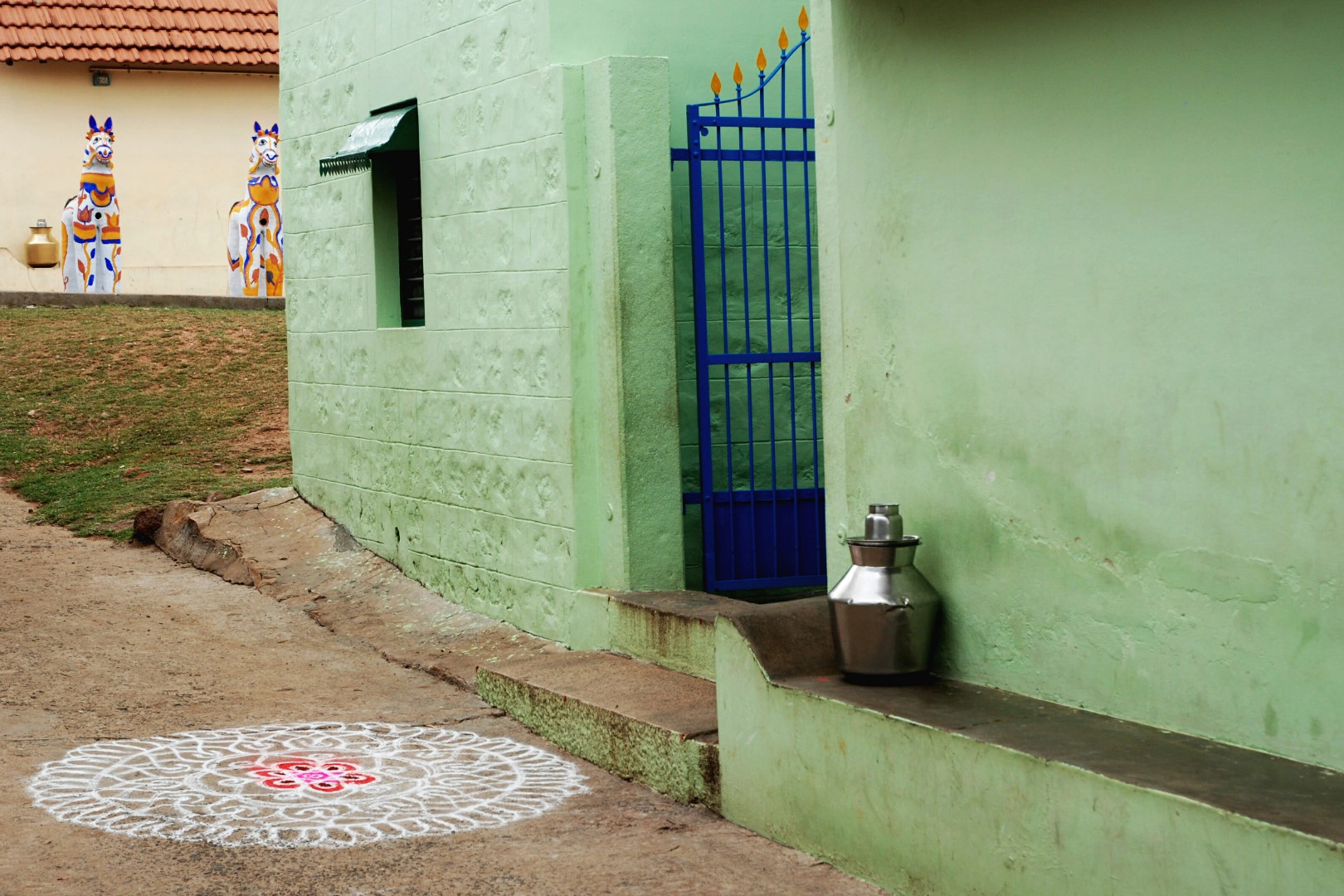 <span style="font-weight:normal;">Just an hour before the festival begins, this small potters' village is spick and span as it awaits a small crowd of devotees. A beautiful <i>kolam</i> has been traced on the street where the cortege will pass, and metal urns filled with drinking water are on hand to quench the thirst of Ayyanar's devotees.</span>