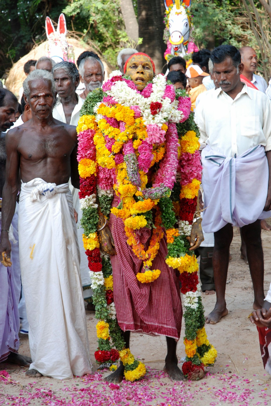 <span style="font-weight:normal;">Weighed down by dozens of garlands given as offerings, the <i>sami-adi</i>’s transformation is complete: where a man stood just minutes ago, the god Ayyanar has taken his place among his followers.</span>