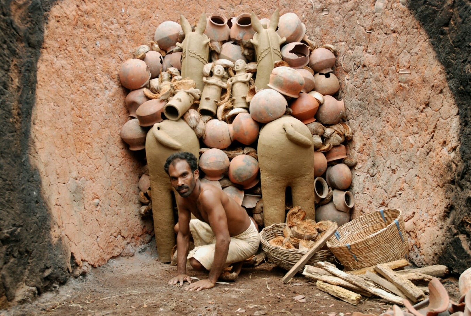 <span style="font-weight:normal;">Jaganathan has started arranging the dried pieces and the combustible material (wood and coconut shells and husk) in the oven. The clay pots and shards are used as air ducts for the easy circulation of heat.</span>