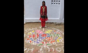 Sukkanya poses with the kolam she and her sister traced that morning